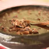 Concha tirando feijão carioca de caldo grosso e encorpado de uma panela