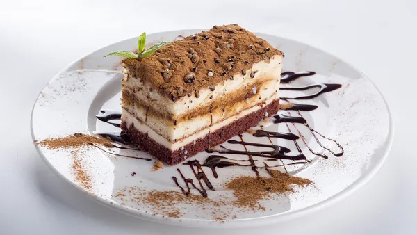 Bolo de cenoura alto e fofo cortado, com cobertura de chocolate brilhante escorrendo pelas laterais