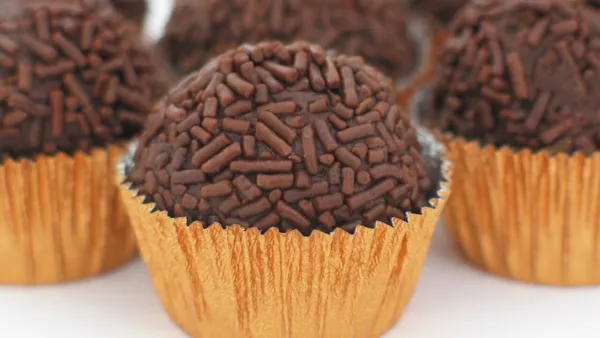 Panela com brigadeiro de chocolate brilhante deslizando em bloco único ao inclinar