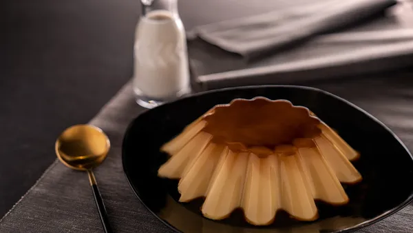 Fatia de pudim de leite condensado liso e firme com calda de caramelo escorrendo