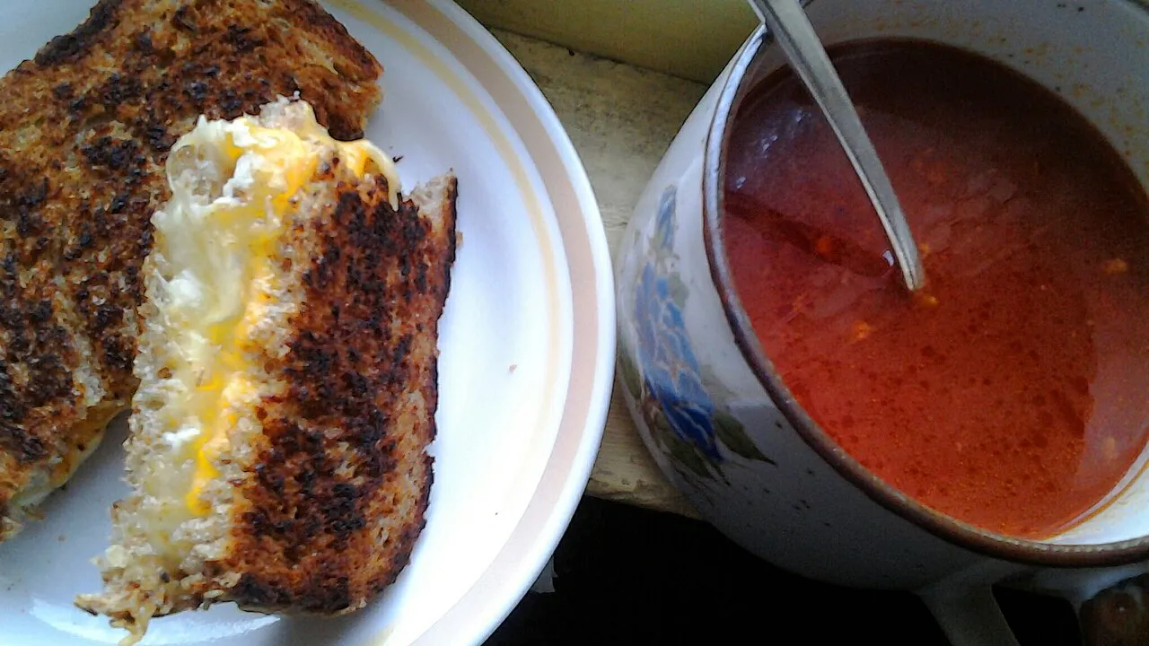 Panela com molho de tomate caseiro vermelho intenso e encorpado, escorrendo de uma colher de pau sobre macarrão